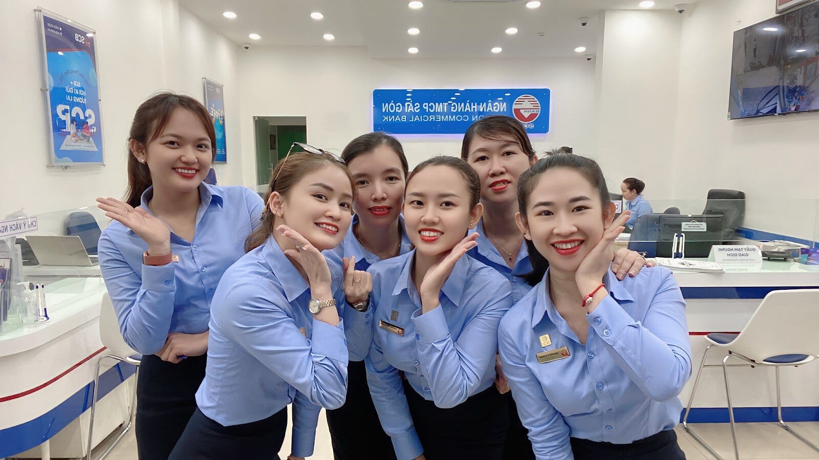 Mẫu 2: Đồng phục nhân viên tài chính thanh lịch với áo sơ mi trơn xanh dương phối chân váy bút chì hoặc quần tây.